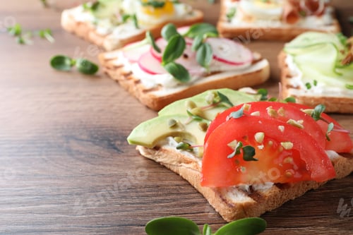 Preview: Different delicious sandwiches with microgreens on wooden table, closeup