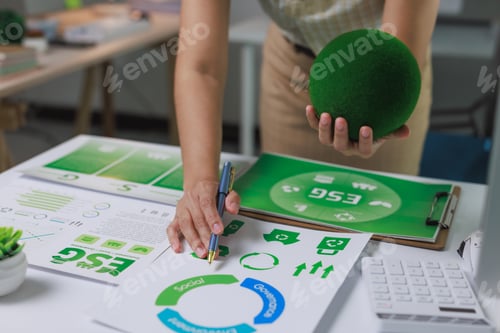 Preview: Businesswoman analyzing esg report with green sphere concept
