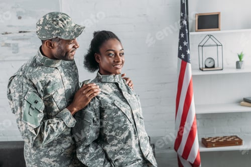 Preview: African american male soldier embracing woman in camouflage clothes