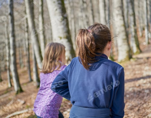 Preview: Shallow focus shot of a young female walking in a forest with her mother