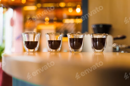 Preview: Flavored espresso double glass coffee with sunlight on wooden cafe table,