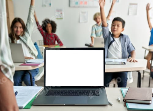 Preview: Laptop computer white blank empty mockup screen on teachers table in classroom.
