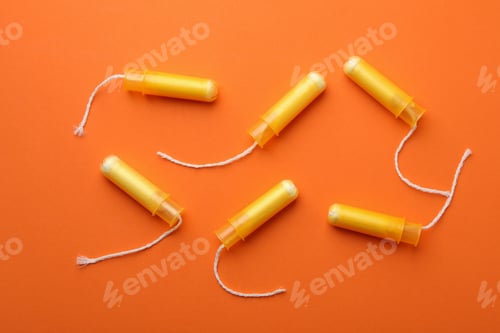 Preview: Women tampons on orange background, top view