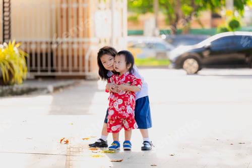 Preview: Asian older sister tenderly embraces her beloved younger brother.