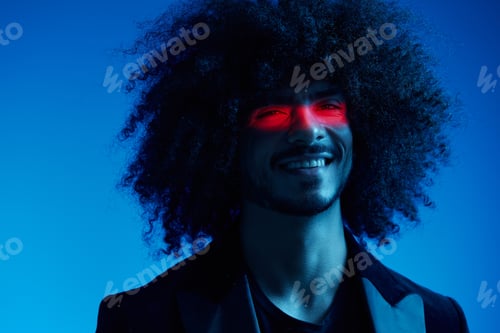 Preview: Fashion portrait of a man with curly hair on a blue background with a red stripe of light