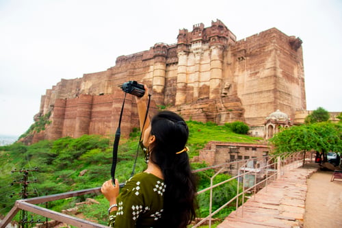 Preview: Portrait of young woman with camera at Jodhpur the blue city in Rajasthan India