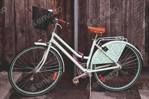 Preview: Mint green retro bicycle parked on a street against rustic wooden wall