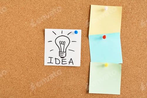 Preview: painted light bulb with word idea and colored blank notes on a cork board