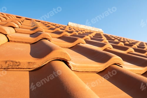 Preview: Overlapping rows of yellow ceramic roofing tiles covering residential building roof
