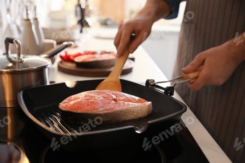 Preview: Man cooking fresh salmon steak in frying pan, closeup