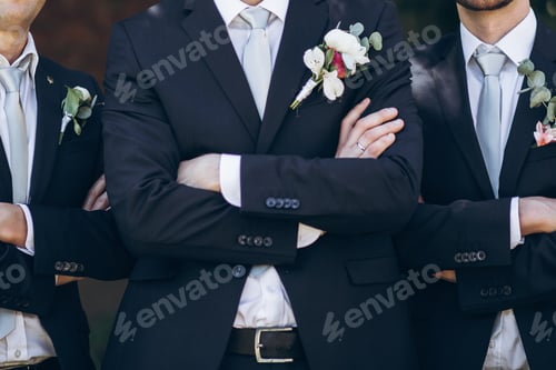 Preview: Stylish groom in suit posing with groomsmen in garden on wedding day