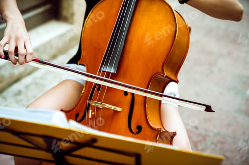 Preview: Happy young female musician playing the cello