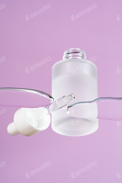 Preview: Transparent dropper bottle with retinol serum on a glass surface in spilled liquid. Trendy
