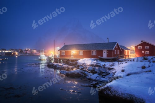 Preview: Beautiful norwegian Rorbu on sea cost and snowy mountain at night