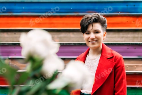 Preview: Candid portrait Young Brunette woman with short hair and white rose flowers on city street. Outdoor