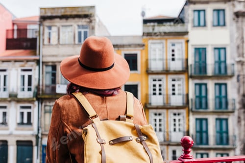 Preview: young caucasian backpacker woman sightseeing Porto views. Travel and friendship concept