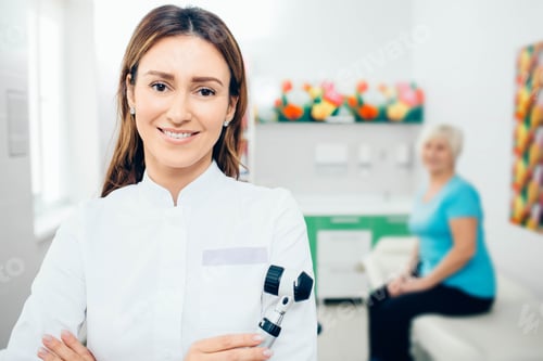 Preview: Doctor dermatologist with dermatoscope, smiling while looking at camera