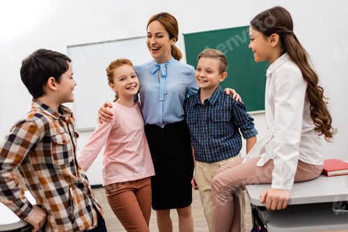 Visualização: Professora risonha abraçando alunos na frente do quadro negro na sala de aula