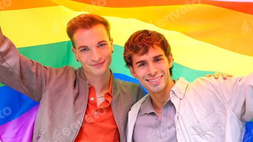 Preview: Gay couple celebrating inclusion with rainbow flag during Pride