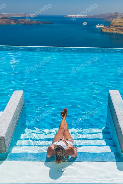 Preview: Woman enjoying relaxation in pool and looking at the view