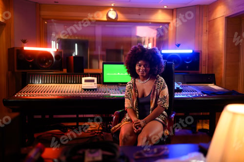 Preview: Hispanic woman music producer and sound engineer sitting at the soundboard