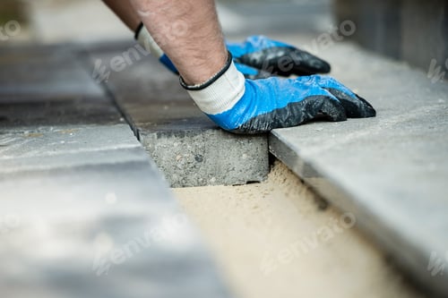 Preview: Builder laying new paving bricks