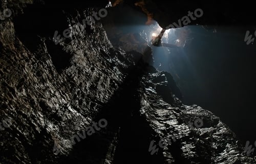Preview: Speleologist abseiling in a vertical cave, pothole on a rope