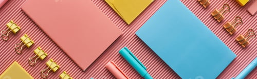 Preview: panoramic shot of colorful stationery supplies on pink