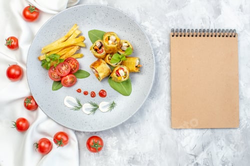 Preview: top view vegetable pate rolls with tomatoes and french fries inside plate on white surface meal