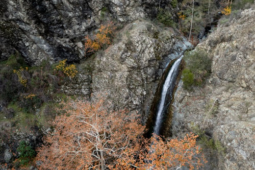 Preview: Drone aerial of waterfall flowing from a rocky cliff in autumn. Nature landscape.