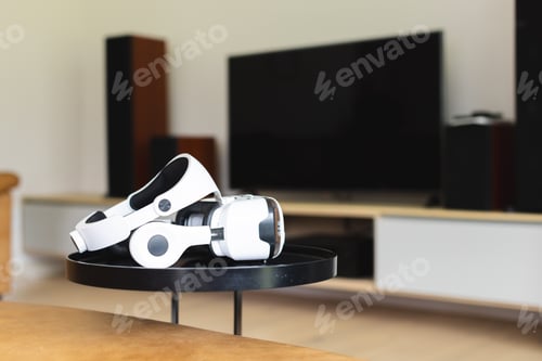 Preview: A white virtual reality headset rests on a black table in a modern living room with copy space