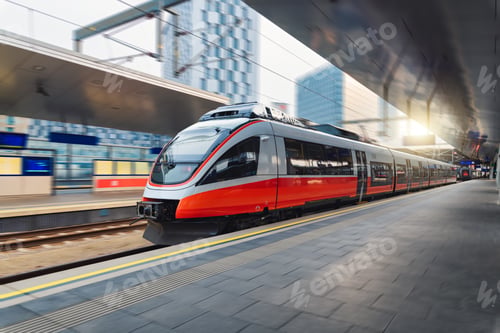 Preview: Red high speed train in motion on the railway station at sunset