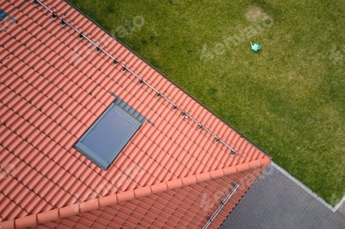 Preview: Closeup of attic window on house roof top covered with ceramic shingles. Tiled covering of building