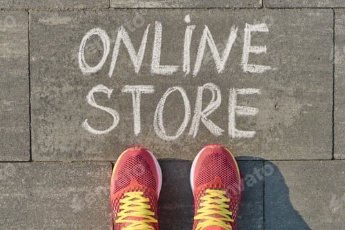 Preview: Word online store written on gray sidewalk with women legs in sneakers, top view