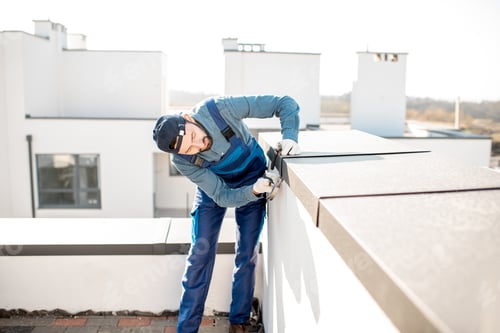 Preview: Builder mounting metal cover on the parapet of a new building