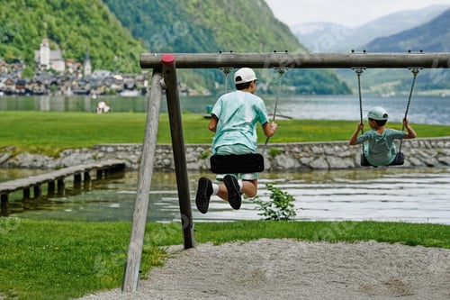 Preview: Two brothers ride on a swing at Hallstatt, Austria.