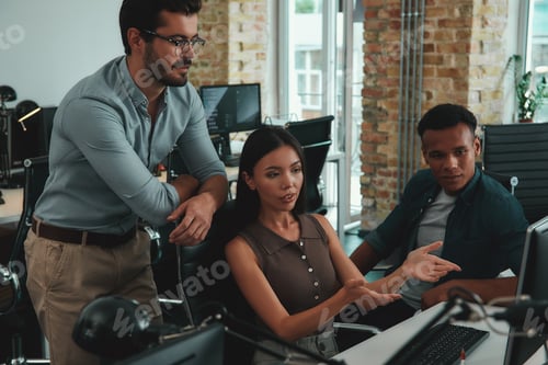 Preview: Talking about business. Multiethnic group of young people looking at computer monitor and discussing