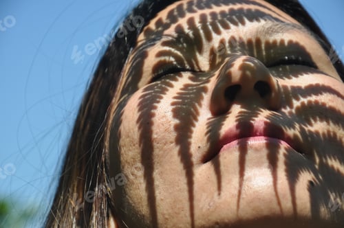 Preview: Closeup shot of fern leaf shadow on a asian girl face, Close-up of a girl real face with pores