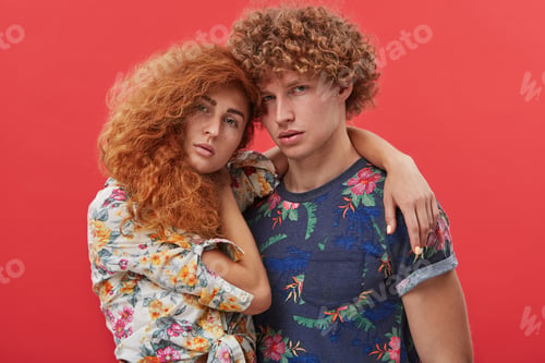 Preview: Indoor picture of fashionable young Caucasian couple dressed in trendy wear with flower pattern, hug