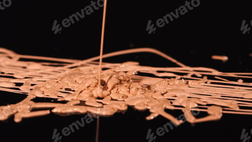 Preview: Close up view of beige makeup concealer pouring on black background