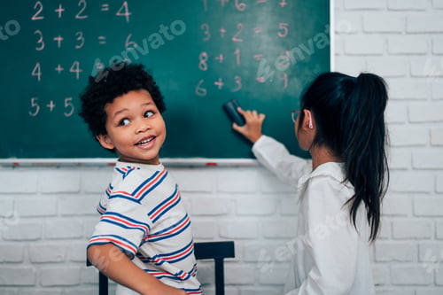 Preview: Happy school teacher and students having interesting engaging activities in class.