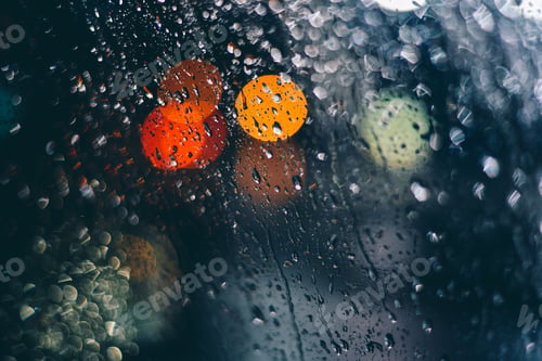 Preview: Closeup of raindrops on the window with colorful bokeh lights in the background