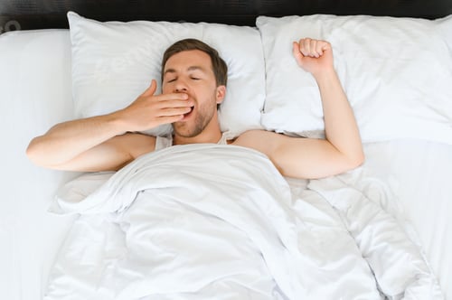 Preview: Cute young man sleeping on bed