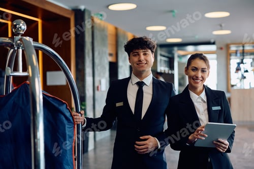 Preview: Young happy hotel staff looking at camera.
