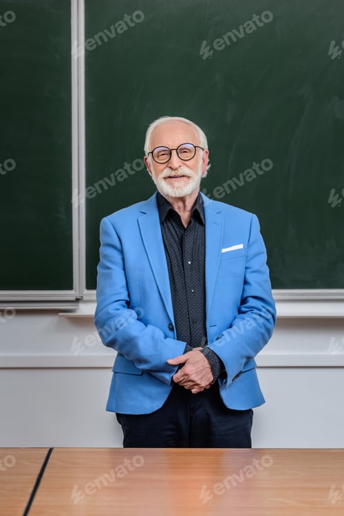 Preview: smiling senior lecturer standing in classroom and looking at camera