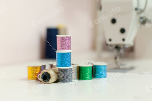 Preview: Sewing accessories on the desktop close-up. Sewing threads from lurex in spools