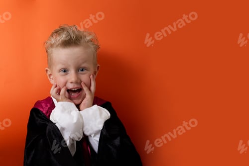 Preview: A boy in a vampire costume emotionally looks at the camera on an orange background
