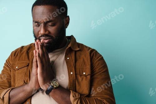 Preview: Focused african american man posing with palms together