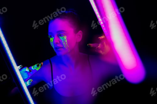 Preview: Cyberpunk. Girl with stylized makeup in the light of neon lamps.