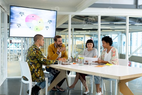 Preview: Side view of diverse business people discussing over documents in the conference room at office
